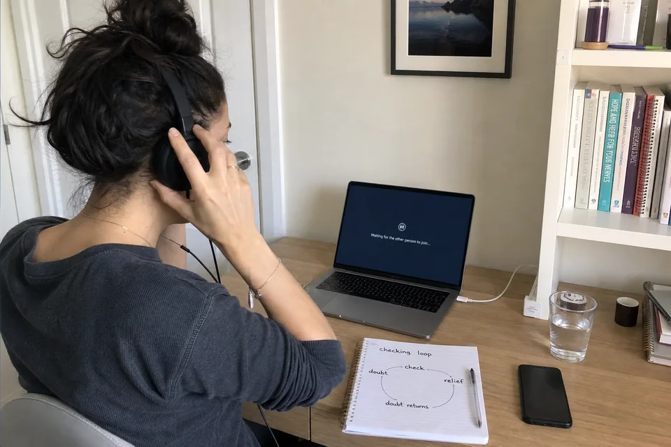 Una mujer prepara sus notas y un espacio privado para una sesión online.